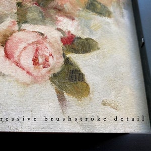 May include: Close-up of a framed oil painting of pink roses with green leaves. The painting has a textured surface and the text "impressive brushstroke detail" is visible at the bottom.