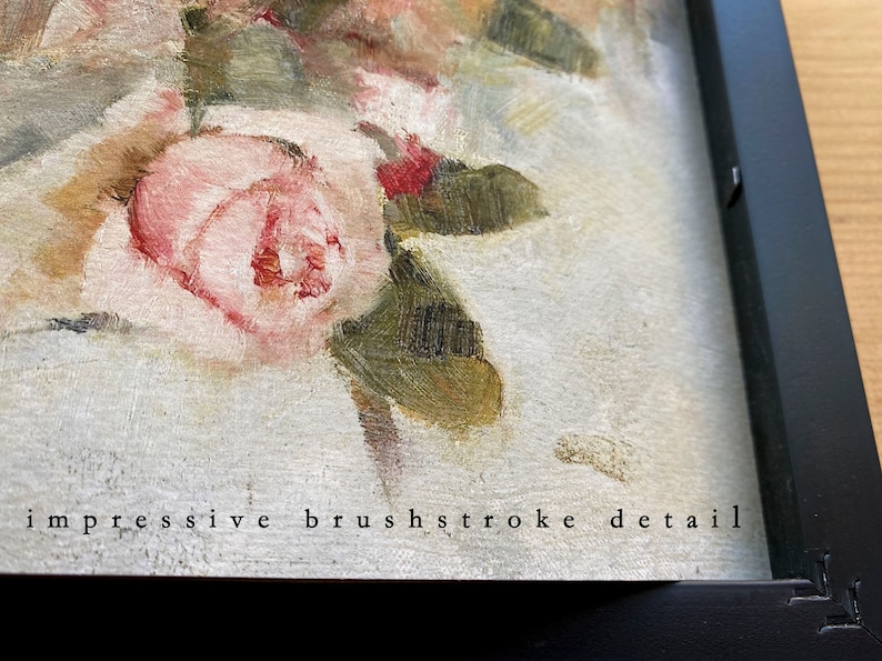 May include: Close-up of a framed oil painting of pink roses with green leaves. The painting has a textured surface and the text "impressive brushstroke detail" is visible at the bottom.