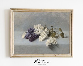 May include: A framed print featuring a still life of lilacs. The artwork showcases a cluster of white and purple lilacs with green leaves against a muted gray background. The frame is a light gold color, and the print is from the Patina Print Shop.