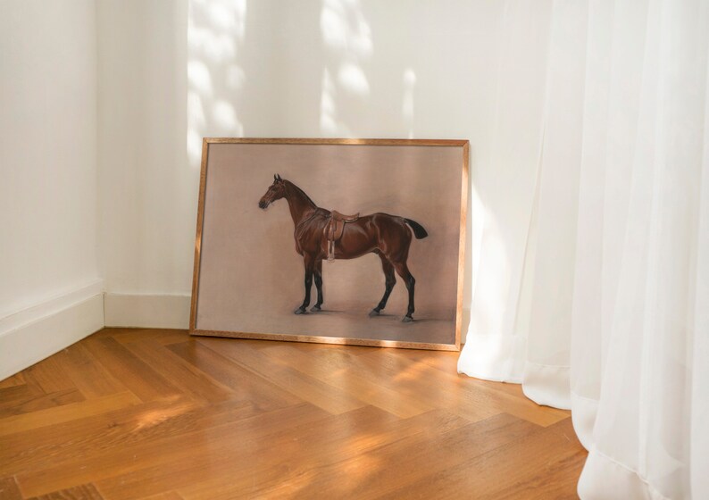 May include: A framed print of a brown horse with a saddle, standing on a light brown background.