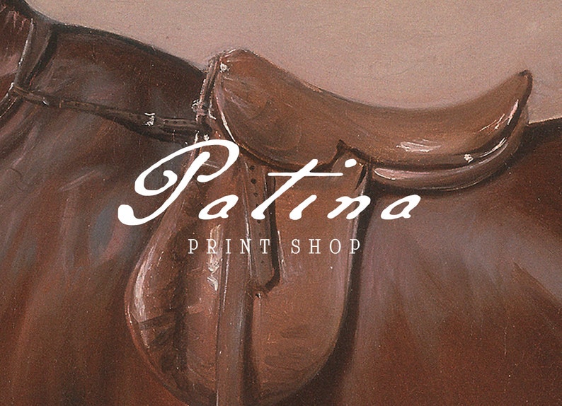 May include: A brown leather saddle with the text "Patina Print Shop" in white lettering.