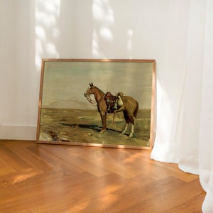 May include: A framed painting depicting a brown horse with a rider in a field. The painting is in a wooden frame and has a rustic feel.