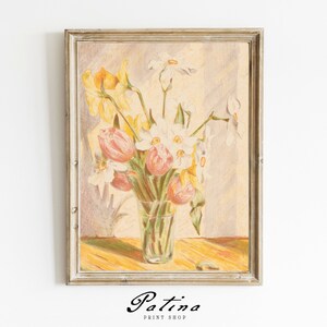 May include: A framed painting of a bouquet of yellow and white flowers, including daffodils and tulips, in a clear glass vase. The flowers are painted in a realistic style with soft pastel colors.