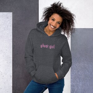 May include: A dark gray hooded sweatshirt with the words "ghost girl" embroidered in pink on the front.