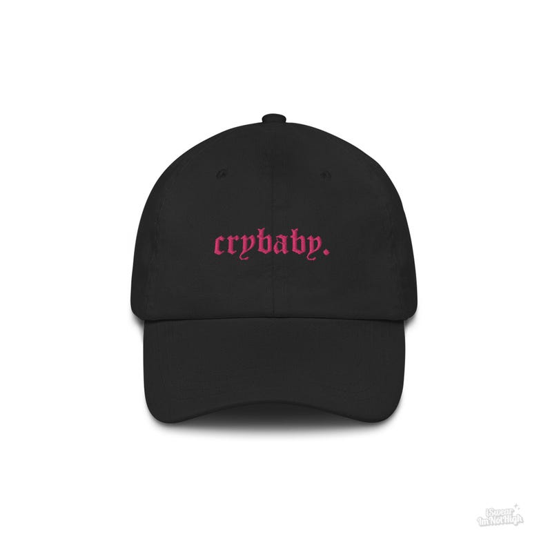 Puede incluir: Una gorra de b&eacute;isbol negra con texto bordado en rosa que dice "crybaby."