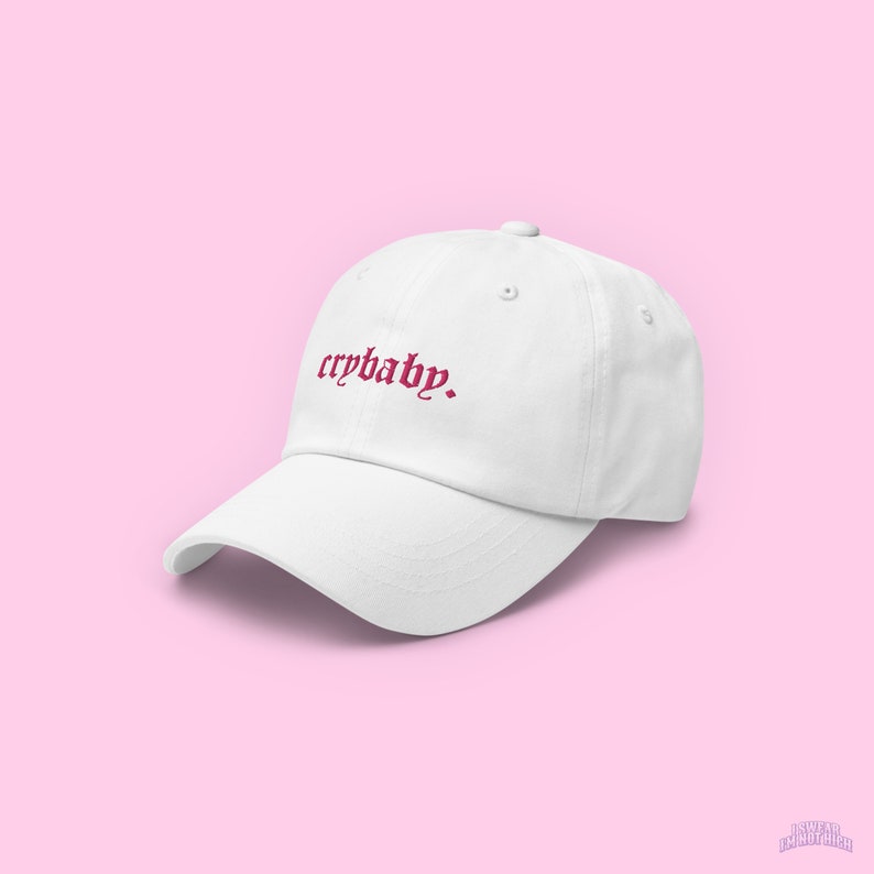 Puede incluir: Gorra de b&eacute;isbol blanca con un texto bordado en rosa que dice "crybaby."