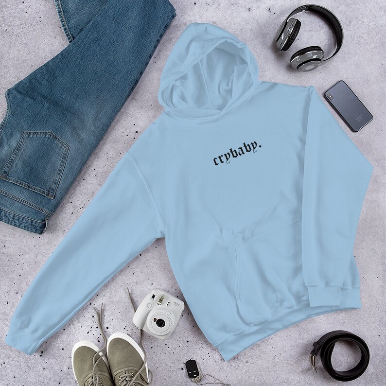 May include: Light blue hooded sweatshirt with the text "crybaby." in black gothic font.