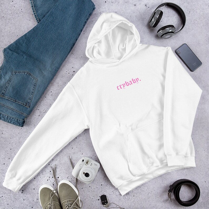 May include: White hooded sweatshirt with a pink "crybaby" graphic printed on the front.