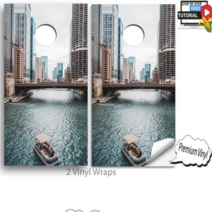 May include: Two vinyl wraps featuring a cityscape with a river and boats. The wraps are designed to fit a cornhole board. The image shows what the finished product will look like.