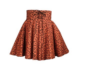 May include: An orange skirt with a high waist and a flared silhouette. The skirt is patterned with black bat shapes. The waist features a lace-up detail in the back.