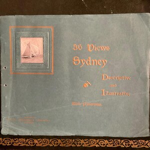 May include: A vintage book cover with a blue background and gold lettering. The title is "36 Views Sydney Descriptive and Illustrative with Panorama". A small image of a sailboat is in the upper left corner.