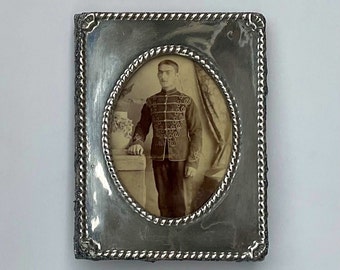 Fotografía antigua en sepia: Soldado victoriano en un marco de fotos de níquel repujado