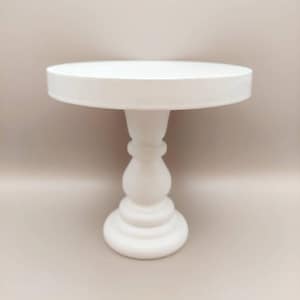 May include: White cake stand with a round top and a pedestal base. The stand is made of wood and has a smooth, white finish.