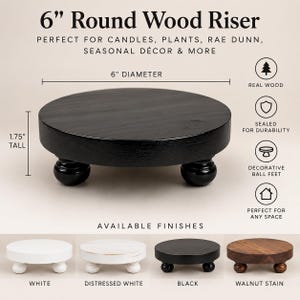 May include: A round black wood riser with decorative ball feet, measuring 6 inches in diameter and 1.75 inches tall. The image displays text including 6" Round Wood Riser, and shows four finish options: white, distressed white, black, and walnut stain.