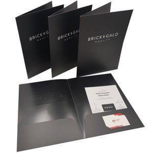 May include: Three black presentation folders with the white text BRICK & GALO REALTY on the front. One folder is open, revealing an interior pocket containing a white EDASI Rewards ONYX PASS card and a small white business card with red accents.