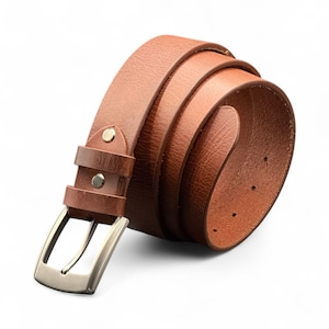 May include: A rolled-up brown leather belt with a silver-colored buckle. The belt has a textured surface and is fastened with a metal buckle. The belt is a classic accessory.