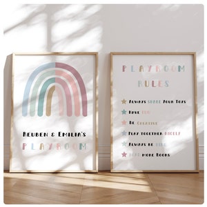 May include: Two framed prints for a playroom. The left print features a rainbow in pastel colours with the text "Reuben & Emilia's Playroom". The right print has the text "Playroom Rules" and lists rules for sharing toys, having fun, being creative, playing together nicely, being kind, and reading more books.