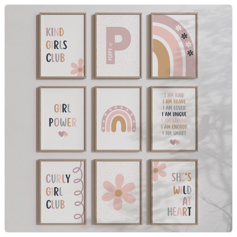 May include: Nine framed prints with a pink and brown color scheme. The prints feature various designs including a rainbow, a flower, and text that reads "Kind Girls Club", "Girl Power", "Curly Girl Club", "She's Wild at Heart", and "I am Kind, I am Brave, I am Loved, I am Unique, I am Strong, I am Enough, I am Smart".