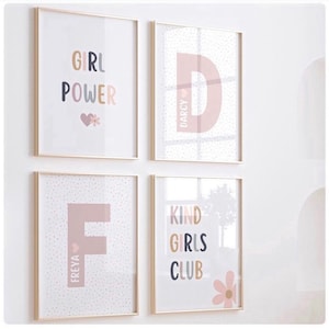 May include: Four framed prints with a pink and white polka dot background. The prints feature the words "Girl Power", "Kind Girls Club", and the letters "D" and "F" with the names "Darcy" and "Freya" written vertically next to them.