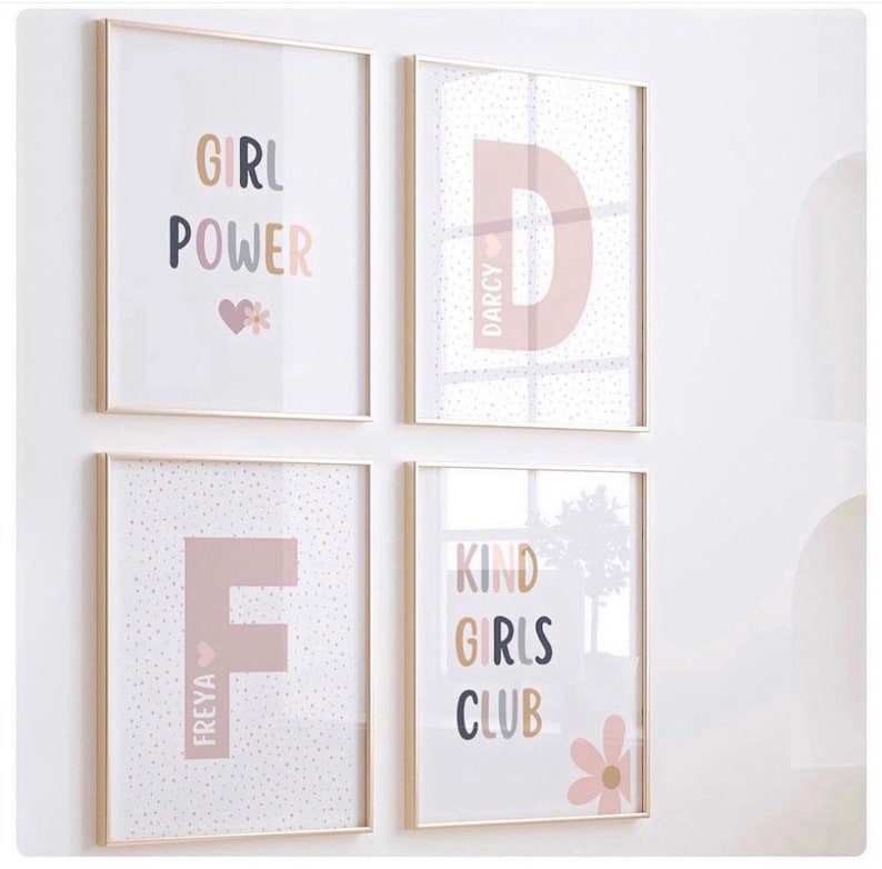 May include: Four framed prints with a pink and white polka dot background. The prints feature the words "Girl Power", "Kind Girls Club", and the letters "D" and "F" with the names "Darcy" and "Freya" written vertically next to them.