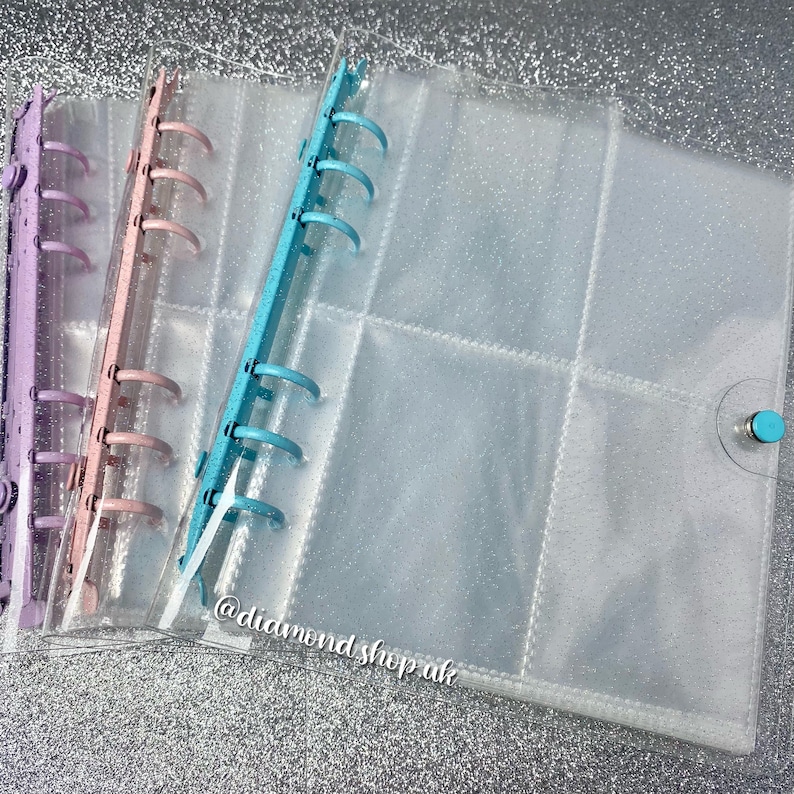 May include: Three clear plastic binder covers with different colored rings. The covers have a glittery finish and are designed to hold loose leaf paper. The text '@diamond_shop_uk' is visible on the bottom right corner of the image.