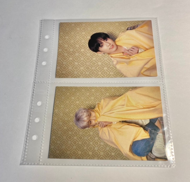 May include: Two photo cards featuring two different men in a yellow robe. The men are sitting in a room with a patterned wallpaper. The photo cards are in clear plastic sleeves.