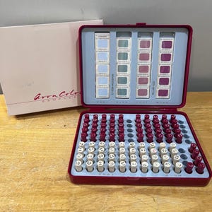 May include: A vintage Avon Color Sampler makeup kit. The open red case reveals eyeshadow and blush samples, along with a selection of lipstick testers. The kit includes a matching box with the Avon logo.