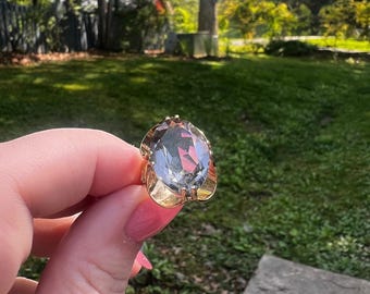 Anillo de cóctel grande ovalado facetado de cristal ahumado, estilo retro MCM, tono dorado.