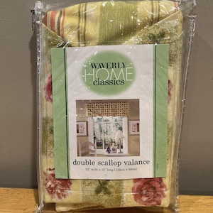 May include: A packaged Waverly Home Classics double scallop valance. The valance is 52 inches wide and 15 inches long. The fabric has a floral and striped pattern in shades of yellow, green, and red.