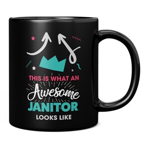 Peut inclure: Mug à café noir avec un motif blanc qui dit "Ceci est à quoi ressemble un super gardien". Le motif comprend également une couronne, des étoiles et des flèches.