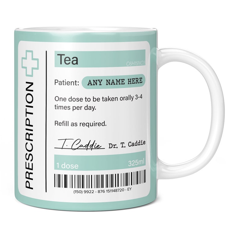 May include: A white ceramic mug with a light blue design that looks like a prescription label. The mug says "Tea" and has a cross symbol. The text on the label says "Patient: ANY NAME HERE" and "One dose to be taken orally 3-4 times per day. Refill as required." The label also has a signature that says "T. Caddie" and "Dr. T. Caddie". The mug has a barcode and the text "1 dose" and "325ml".