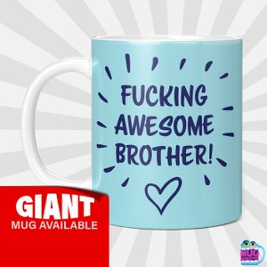 May include: A light blue ceramic mug with a white handle. The mug has the text "FUCKING AWESOME BROTHER!" in navy blue lettering with a heart symbol below the text. The mug is on a white and light blue striped background.