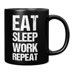 May include: Black coffee mug with white text that reads "Eat Sleep Work Repeat".