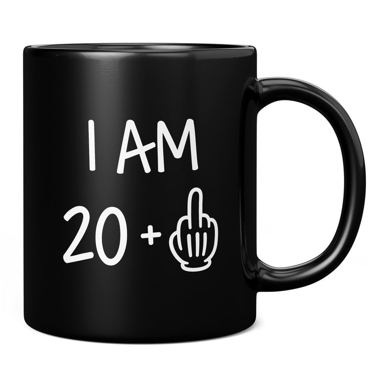 May include: Black ceramic coffee mug with white text that reads "I AM 20 +" with a middle finger emoji.