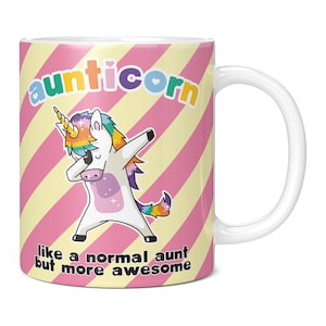 May include: White ceramic mug with a pink and yellow striped background. A cartoon unicorn is doing the dab with rainbow colors. The text "aunticorn" is in rainbow colors and the text "like a normal aunt but more awesome" is in black.