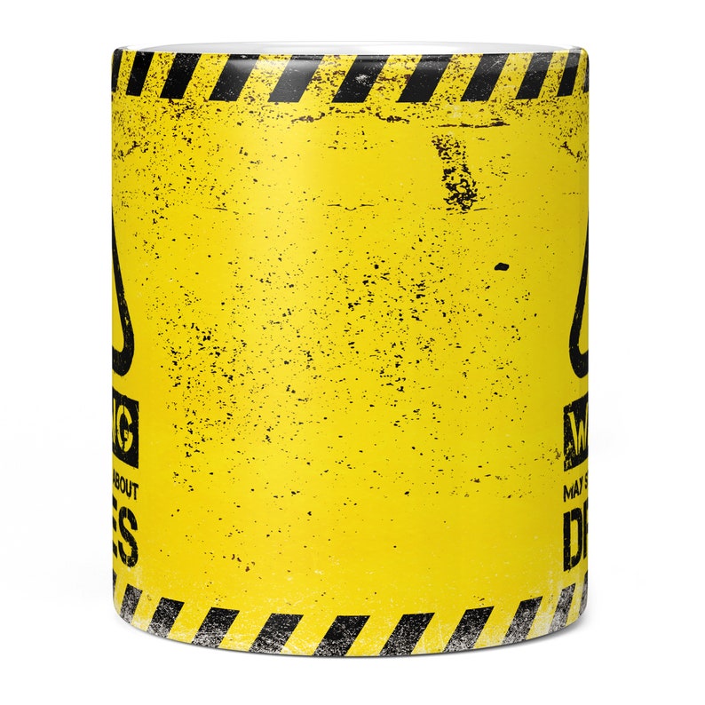 May include: Yellow coffee mug with a black warning sign that says "Warning May Cause Dreams". The sign has a black and yellow striped border.