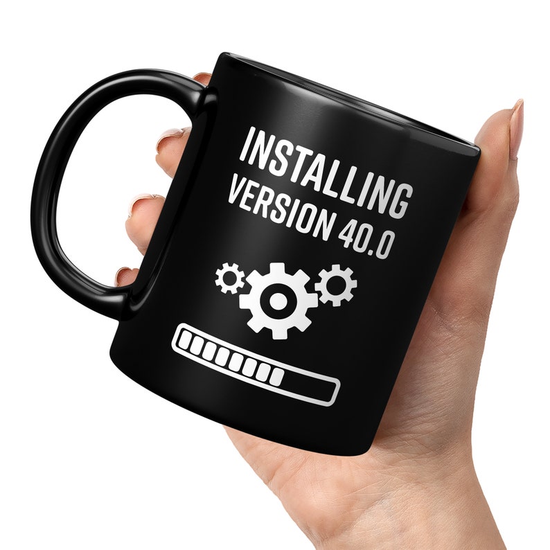 May include: Black ceramic mug with a white graphic that says "Installing Version 40.0" with a progress bar and three gears.