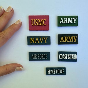 May include: Six rectangular patches with the names of the branches of the United States Armed Forces: USMC, Army, Navy, Air Force, Coast Guard, and Space Force.
