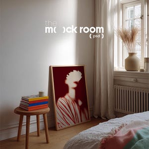 May include: A room interior featuring a framed artwork with a red background and a figure with white accents. A small wooden stool holds a stack of books with colorful spines. The text "the mock room (psd)" is visible on the wall.
