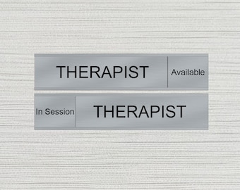 Puede incluir: Dos letreros de metal plateado con la palabra "THERAPIST" impresa en negro. El letrero superior dice "Disponible" y el letrero inferior dice "En sesión".
