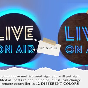 May include: Two round wooden signs with the text "LIVE ON AIR" in white neon lettering. The sign on the left has a blue light around the edge and the sign on the right has a white light around the edge. The text "white-blue" is written on a piece of paper next to the sign on the left. The text "MULTICOLOR" is written on a piece of paper next to the sign on the right. A remote control with 12 different colored buttons is in the bottom right corner of the image.