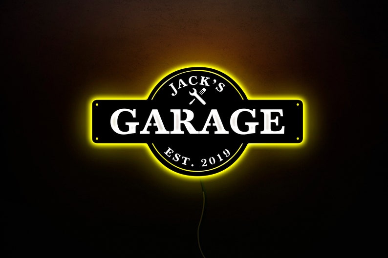 May include: Black and yellow neon sign with the text "Jack's Garage Est. 2019" and a wrench and screwdriver symbol.