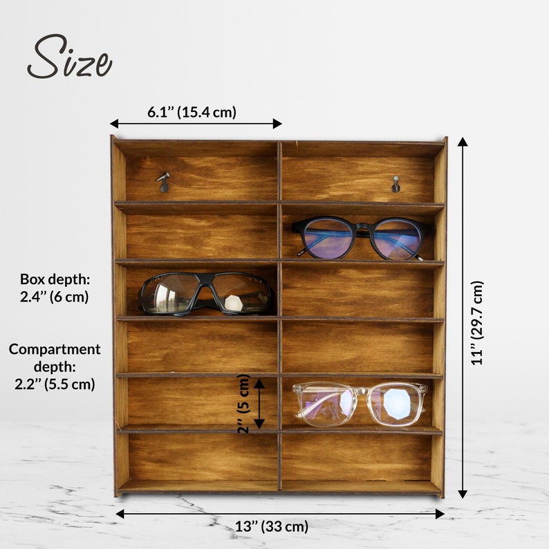 May include: Wooden glasses display stand with 12 compartments. The stand is 13 inches wide, 11 inches tall, and 6.1 inches deep. Each compartment is 2 inches tall and 2.2 inches deep.