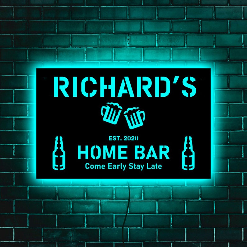 May include: Black neon sign with white text that reads "Richard's" with two beer mugs and the text "EST. 20(20) HOME BAR Come Early Stay Late".