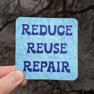 May include: A blue sticker with the words "Reduce Reuse Repair" in a stylized font.