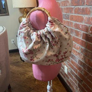 Bolso de mano de alta costura, único en su tipo, hecho a mano, de estilo coqueto, de tela floral vintage de color rosa y con asas de bambú.