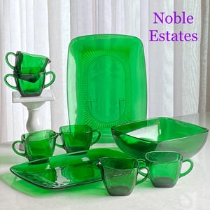 Peut inclure: Un ensemble de plats de service en verre vert émeraude, comprenant un grand bol, un plat rectangulaire et plusieurs petites tasses. Les plats sont tous en verre épais et résistant et présentent un design classique et élégant. L'ensemble est étiqueté "Noble Estates".