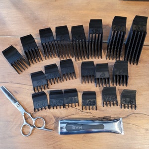 May include: A collection of black clipper guards of various sizes, a pair of silver scissors, and a silver and black hair clipper are arranged on a wooden surface. The clipper guards are labeled with numbers indicating cutting lengths.