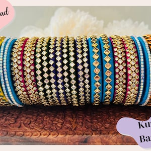 May include: A stack of colorful silk thread bangles with kundan embellishments. The bangles are in shades of yellow, orange, blue, green, and pink. The text "Silk Thread!" and "Kundan Bangles" is visible in the image.