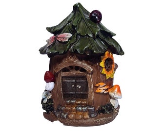 May include: A small, brown fairy house with a green leaf roof, a sunflower on the side, and a red mushroom in front. The house has a brown door with two panels and a small porch with stone steps.